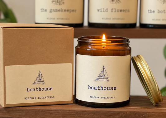 WILDOAK BOTANICALS BOATHOUSE sea salt and driftwood soy candle in a glass jar with a wooden lid, showcasing its natural aesthetic.
