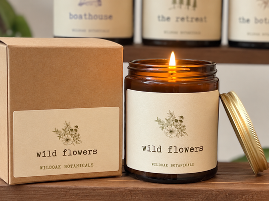 Wild Flowers soy candle by Wildoak Botanicals featuring roses, geraniums, and jasmine in a glass container with floral accents.