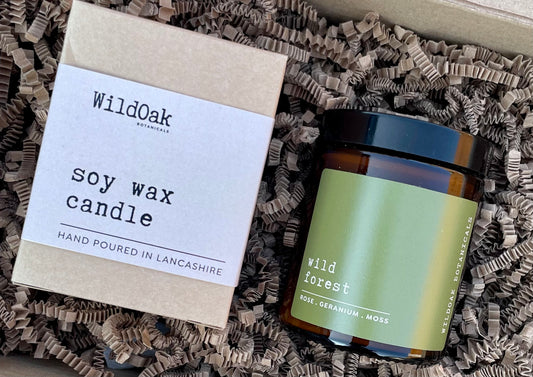 Soy candle from COSYPLACE CANDLE CO. featuring a wild forest scent with rose, geranium, and jasmine, shown in a glass jar.