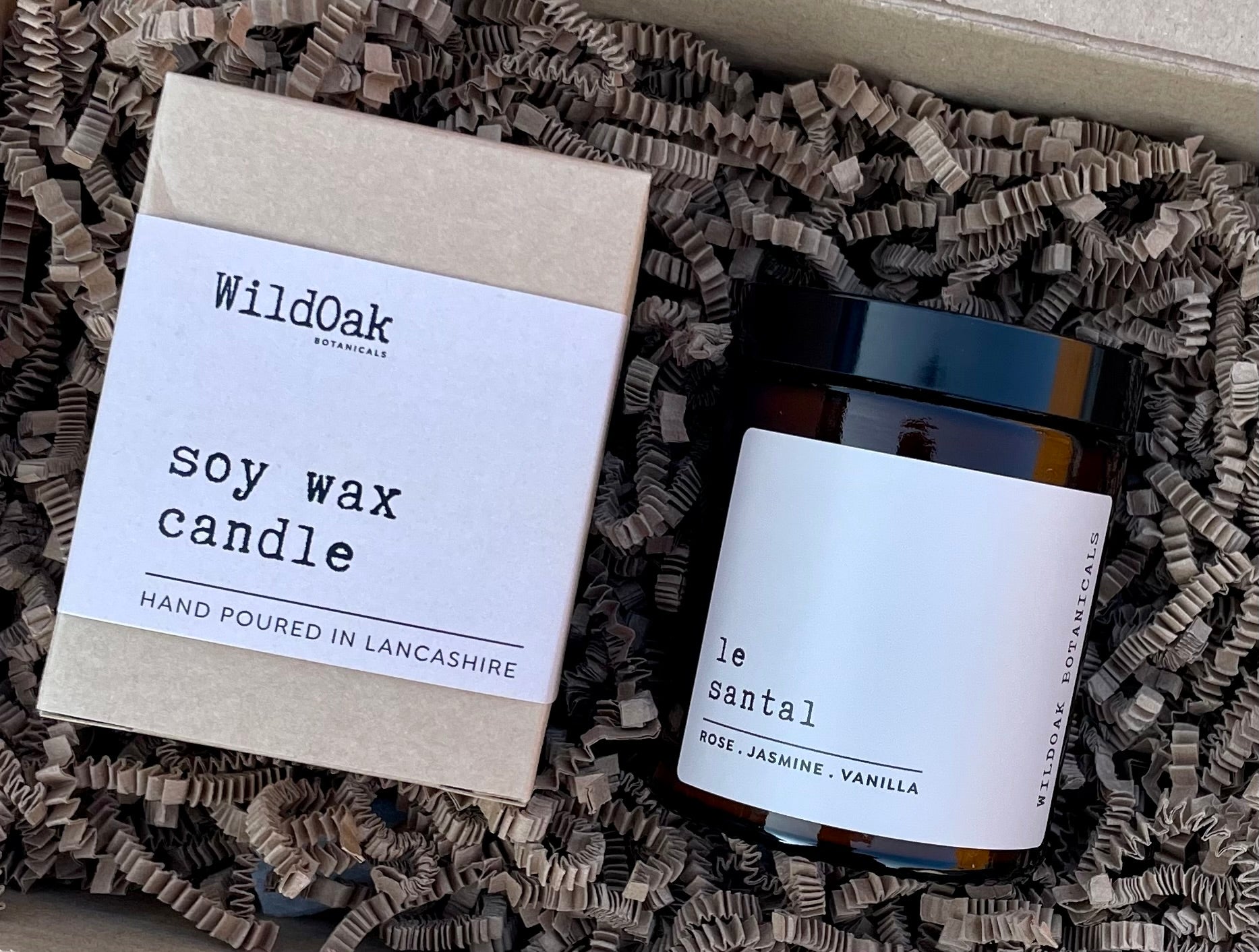 COSYPLACE CANDLES LE SANTAL soy candle with rose, jasmine, and amber scent in a glass container.